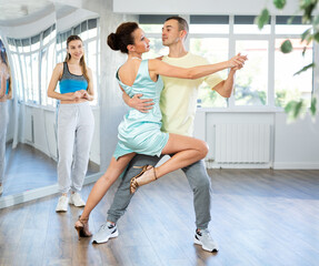 In spacious choreography studio, confident woman professional tango instructor and male student...