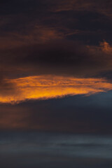 A dramatic and abstract view captures the vibrant colors of clouds illuminated by the low sun during sunset or sunrise