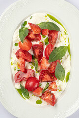 Portion of gourmet tomato appetizer with strawberries and cream