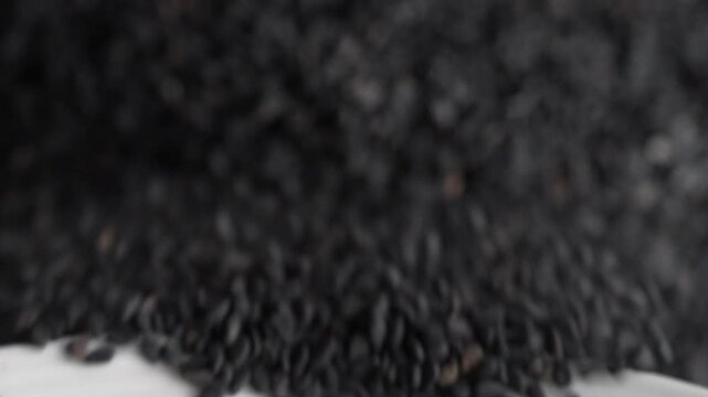 Macro video of black sesame seeds kept on rotating disk. Close up of black sesame seeds.
