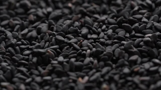 Macro video of black sesame seeds kept on rotating disk. Close up of black sesame seeds.