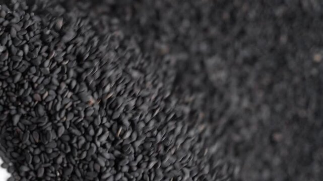 Macro video of black sesame seeds kept on rotating disk. Close up of black sesame seeds.