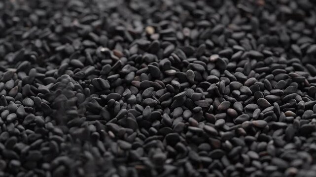 Macro video of black sesame seeds kept on rotating disk. Close up of black sesame seeds.