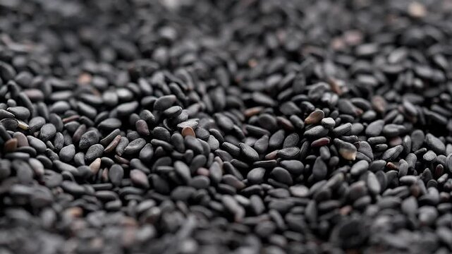 Macro video of black sesame seeds kept on rotating disk. Close up of black sesame seeds.