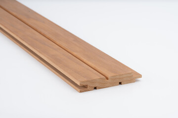 Brown wood molding profile with precision grooves, photographed on white background. Ideal for use in joinery, trim work, or construction detail..