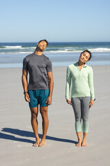 Fototapeta premium Couple stretching necks on beach, enjoying sunny day and relaxing together