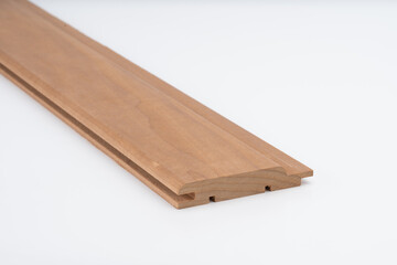 Brown wood molding profile with precision grooves, photographed on white background. Ideal for use in joinery, trim work, or construction detail..