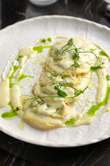 Closeup on portion of italian ravioli dumplings dish with creamy sauce