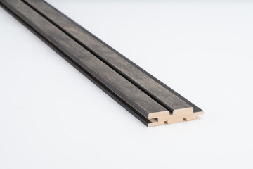 Black-toned wood slat with precise parallel grooves and natural wood edges, shown on white background. Designed for acoustic walls or cladding..