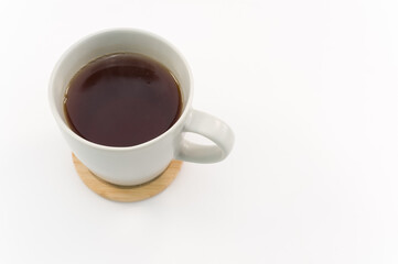 Tazza in ceramica grigia dal design moderno con infuso alle erbe e sottotazza in bamboo, sfondo bianco