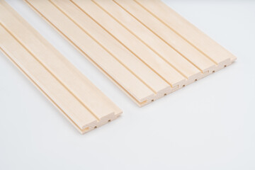 Light wooden wall panels with fluted design and tongue-and-groove connections, neatly laid out on white background. Ideal for decorative interiors..