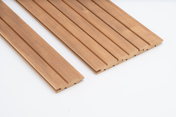 Brown fluted wooden wall panels with tongue-and-groove joints, neatly arranged on a white background. Ideal for decorative or acoustic interiors..