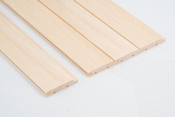 Light wooden slats with subtly curved groove profiles, aligned side by side on a white background....