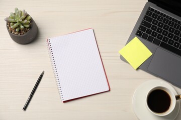Notebook, sticky note, pen, coffee, floral decor and laptop on wooden table, flat lay