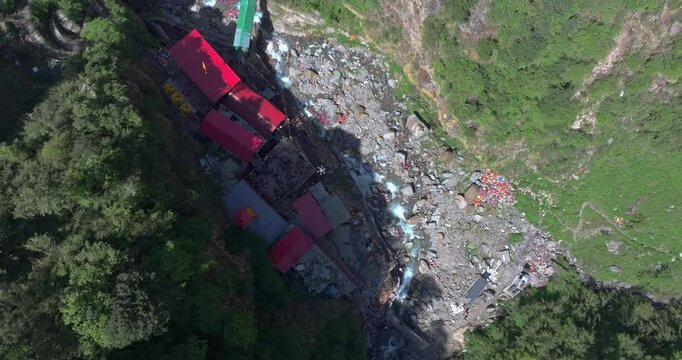 Aerial rotating view of sacred Hindu temple at Yamunotri Dham in the Uttarakhand Himalayas, famous Char Dham pilgrimage destination surrounded by dramatic mountain landscape
