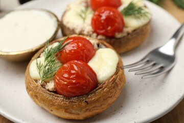 Tasty stuffed mushrooms served on table, closeup