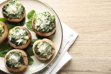 Tasty stuffed mushrooms served on light wooden table, top view. Space for text