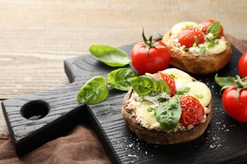 Tasty stuffed mushrooms served on wooden table, closeup