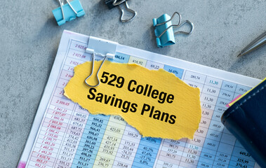 Paper with 529 College Savings Plans text on yellow paper on gray table, Business Concept