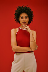 Striking young woman poses confidently against vibrant red backdrop