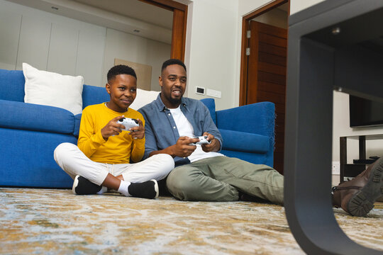 African American father and son playing video games together, enjoying quality time
