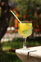 Drink on a garden table on a hot summer day. Glass with cocktail on a wooden table outdoors....