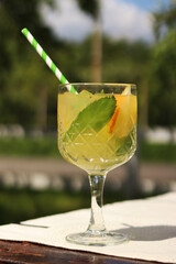 Drink on a garden table on a hot summer day. Glass with cocktail on a wooden table outdoors....