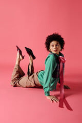 Young woman in stylish outfit poses gracefully on vibrant pink background