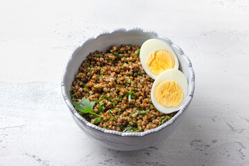 Healthy buckwheat porridge with fresh herbs and boiled eggs