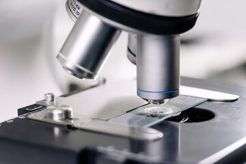 Close-up of scientific microscope with glass, analyzing data in lab, research for vaccine...