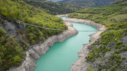 Himalayan footbridge over Lake Monteynard-Avignonet in the French Alps near Grenoble, suspended walkway in scenic mountain landscape, popular hiking destination