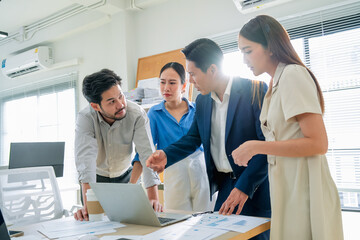 Focused business strategists stand head-to-head in a modern office, concentrating on agile planning...