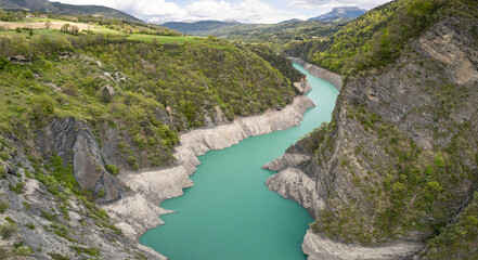 Scenic view of Lake Monteynard-Avignonet in a canyon in the French Alps near Grenoble, turquoise mountain lake surrounded by alpine peaks and forests