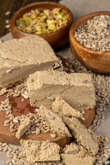 halva from sunflower closeup, a sweet delicious dessert made from fried sunflower seeds, seeds and pistachios in bowls
