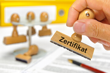 Ein Holzstempel ist beschriftet mit dem Aufdruck Bestätigung