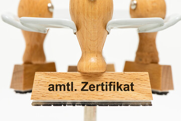 Ein Holzstempel ist beschriftet mit dem Aufdruck amtliches Zertifikat