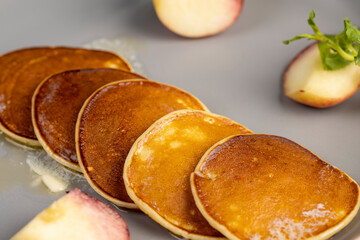 melting butter on hot freshly baked pancakes, several pancakes made from milk with flour on which...