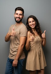 Fototapeta premium Happy young couple displaying thumbs up sign in casual clothing for friendship and positive vibes