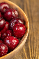 cherry in drops of water, wet cherry on the table closeup, berries in a bowl