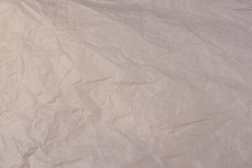 crumpled light-colored wrapping paper after prolonged use