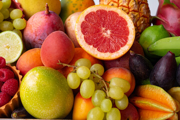 Closeup view of basket full of fresh mixed ripe colorful seasonal fruits. Tropical, seasonal, healthy eating concept
