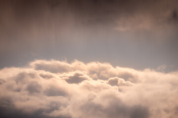 Bright clouds with soft sunlight breaking through a dark sky. A symbolic view of heaven often linked to faith, hope, divine light, and spiritual meaning.
