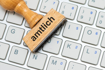 Ein Holzstempel ist beschriftet mit dem Aufdruck amtlich
