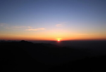 Obraz premium Serene mountaintop sunset silhouette, embracing calm, spiritual journey, golden hour