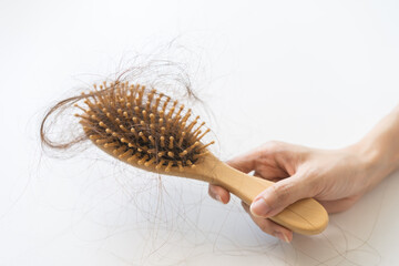 Problem hair, stressed beautiful asian young woman, girl in bathrobe hand holding comb show her hairbrush with hair loss in brush after brushing fall out at home. Health care, beauty with treatment.