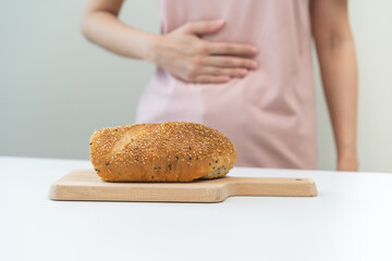 Gluten allergy, asian young woman, girl having a stomach ache hand holding, refusing to eat brown...