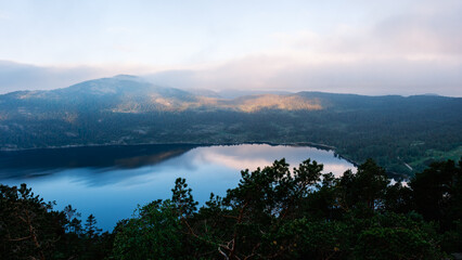 Obraz premium Majestic view over tranquil lake reflecting mountains in Norway at dawn