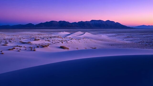 serene landscape of sand dunes against dusky sky with distant mountain range during twilight hour