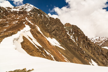 Snow-covered range of mountains from mountain pass over the lake Ala-Kul. Tien Shan. Kyrgyzstan