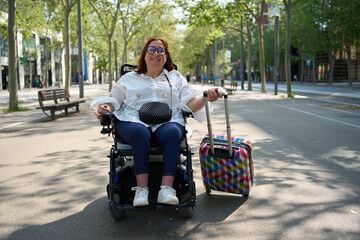 Woman in wheelchair traveling with luggage outdoors - wheelchair and disability concept